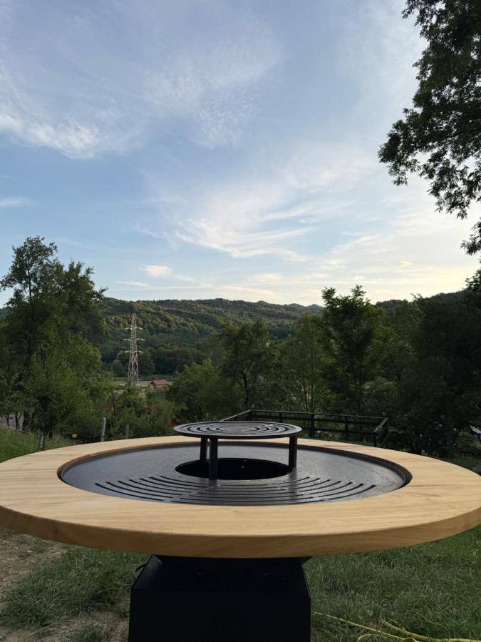 Vatra de foc rotundă din curte, cu priveliște spre vale